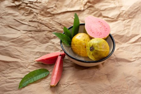 Photo for A closeup of tasty guava fruit in a bowl on a brown paper - Royalty Free Image