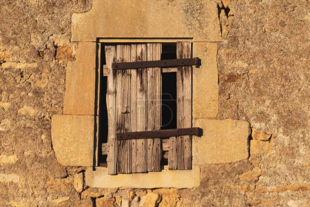 Foto de Edificios de piedra abandonados con una vieja ventana cubierta de tablas de madera - Imagen libre de derechos