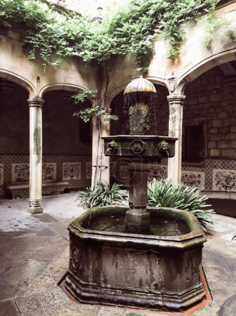 Foto de Un disparo vertical de la fuente de agua de piedra en el patio de la iglesia en Barcelona, España - Imagen libre de derechos