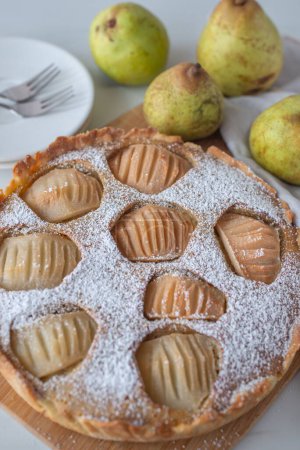 Foto de Un primer plano vertical de crujiente tarta de almendras de pera deliciosa con azúcar en polvo - Imagen libre de derechos
