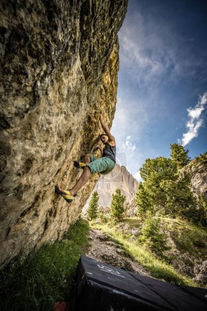Photo for A vertical shot of an active male hiker climbing in the Steinerne Stadt hiking area, Italy - Royalty Free Image