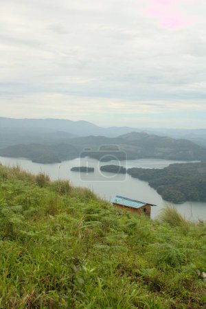 Téléchargez les photos : Vue verticale d'un bâtiment au-dessus d'une rivière contre les collines verdoyantes pittoresques - en image libre de droit