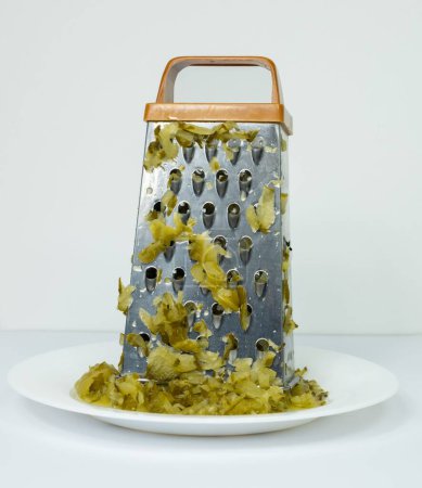 Photo for A vertical shot of a grated covered in sliced pickles on a plate - Royalty Free Image