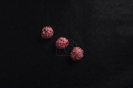 Foto de Un primer plano de deliciosas bolas de pastel con glaseado colorido aislado sobre un fondo oscuro - Imagen libre de derechos