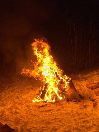 Foto de Un disparo vertical de una gran hoguera en llamas en un camping de playa - Imagen libre de derechos