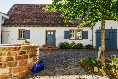 Foto de Una hermosa casa histórica alemana blanca con puertas azules y persianas en tiempo soleado - Imagen libre de derechos