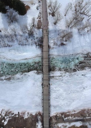 Foto de Una vista aérea de un puente sobre un arroyo rocoso de invierno en Montana, EE.UU. - Imagen libre de derechos
