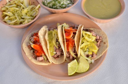 Foto de Un primer plano de deliciosos tacos en un plato redondo con especias y salsas a su lado - Imagen libre de derechos
