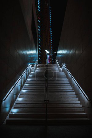 Photo for A low angle vertical shot of a staircase with small neon lights attached from the bottom - Royalty Free Image