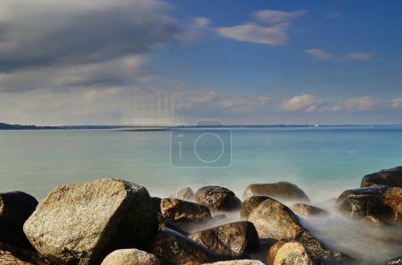 Foto de Un pintoresco disparo de larga exposición de un tranquilo mar capturado en la costa rocosa de Travemunde, Alemania - Imagen libre de derechos