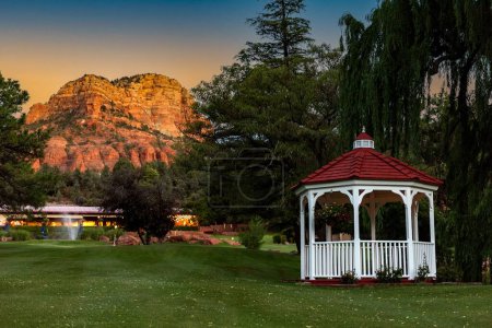 Photo for The Weeping willow and gazebo with red roof on a green lawn in Sedona at sunset, AZ, USA - Royalty Free Image
