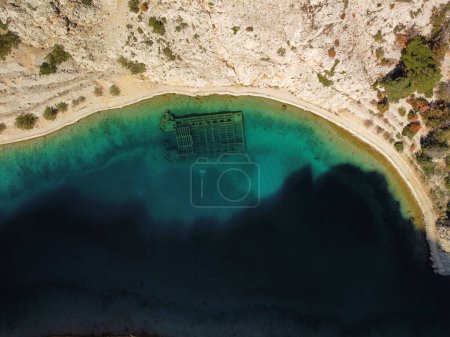 Photo for An aerial top view of the rocky coast of Zavratnica Bay and a shipwreck underwater - Royalty Free Image
