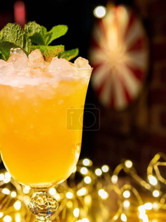 Photo for A vertical shot of a cocktail in a glass and Christmas lights. - Royalty Free Image