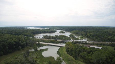 Téléchargez les photos : Un plan de drone d'une rivière pittoresque qui coule dans un espace vert densément végétalisé - en image libre de droit