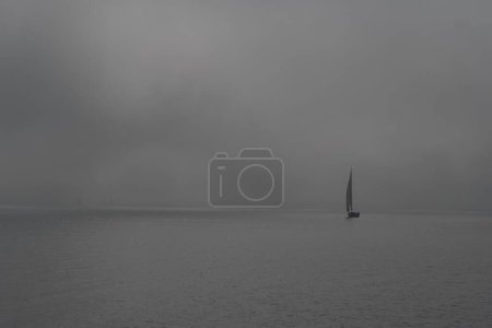 Téléchargez les photos : Un cliché en niveaux de gris d'un voilier dans la mer par une journée brumeuse. - en image libre de droit