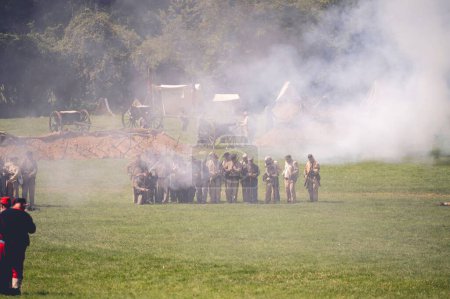 Téléchargez les photos : Un groupe de soldats dans une grande fumée dans un camp militaire pendant la journée de la reconstitution de la guerre civile à Jackson City, Michigan, États-Unis - en image libre de droit