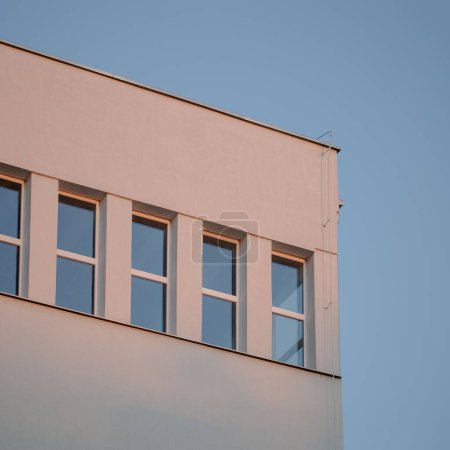 Photo for A closeup of a building corner with windows against a blue sky background - Royalty Free Image