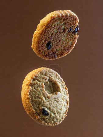 Photo for A closeup of delicious floating chocolate chip cookies isolated on a bright brown background - Royalty Free Image