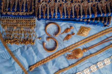 Foto de Un primer plano de joyas y accesorios de boda indios dorados y azules - Imagen libre de derechos