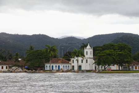 Foto de Un hermoso plano de una catedral rodeada de árboles cerca de un lago en Paraty, Brasil - Imagen libre de derechos
