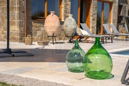 Foto de Una amplia toma de dos botellas de vidrio verde junto a dos ollas de cerámica y dos cestas tejidas y bancos de billar - Imagen libre de derechos