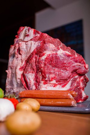 Téléchargez les photos : Gros plan vertical de viande crue placé sur le comptoir à côté des légumes - en image libre de droit