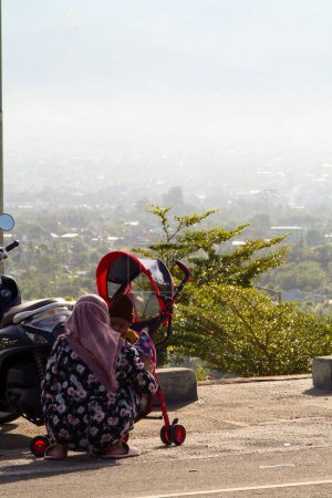 Téléchargez les photos : Plan vertical d'une tante et d'une sœur jouant ensemble dans la rue en Indonésie. - en image libre de droit