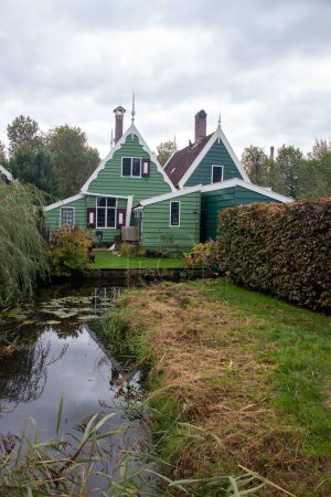 Téléchargez les photos : Un plan vertical de maisons néerlandaises traditionnelles en bois vert dans le Zaanse Schans, Zaanstad, Pays-Bas. - en image libre de droit