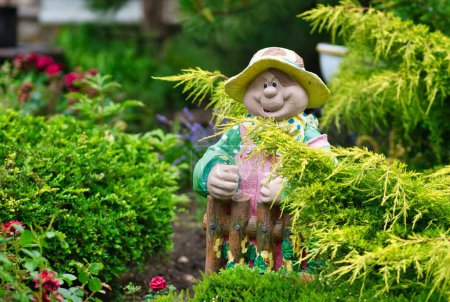 Photo for A close-up shot of a yellow-hatted garden dwarf placed next to plants - Royalty Free Image