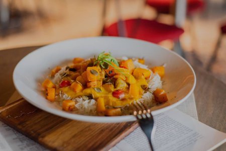 Téléchargez les photos : Un gros plan du plat de curry aux patates douces servi sur une assiette blanche - concept de plat restaurant - en image libre de droit