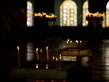 Téléchargez les photos : Les longues bougies dans une église avec un fond sombre - en image libre de droit