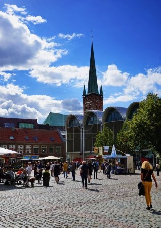 Téléchargez les photos : Vue verticale d'une rue bondée avec un café extérieur et des bâtiments traditionnels à Lubeck, en Allemagne - en image libre de droit