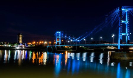 Photo for Anight view of the Suspended Bridge Eng. Marcial Candioti on reflecting bokeh water in Argentina - Royalty Free Image