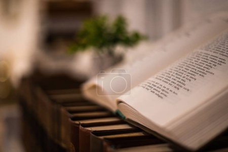 Photo for The Bible opened on old books plased on a wooden commode - Royalty Free Image