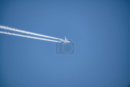 Téléchargez les photos : Un avion à réaction survolés en diagonale avec traînée de condensation. - en image libre de droit