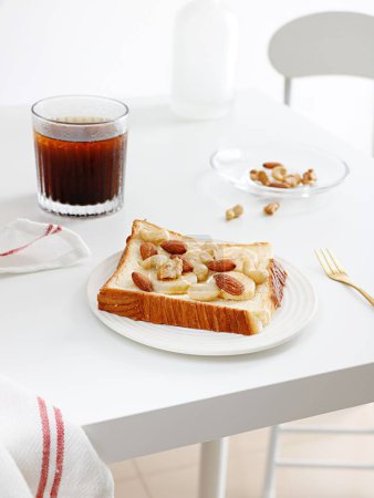Foto de Una vista superior de una tostada de plátano con mantequilla de cacahuete sobre una mesa blanca - Imagen libre de derechos