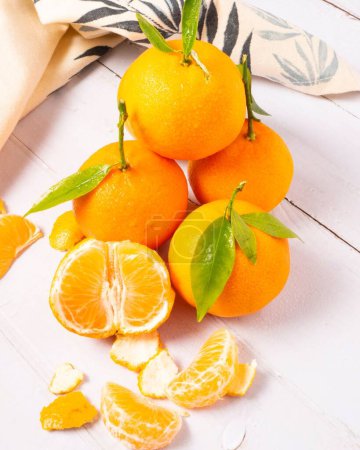 Téléchargez les photos : Un fond d'agrumes orange vif avec des mandarines juteuses sucrées sur une table en bois blanc - en image libre de droit