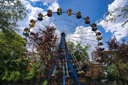 Téléchargez les photos : Une grande roue dans le parc avec un ciel bleu nuageux en arrière-plan - en image libre de droit