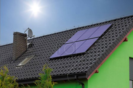 Foto de Paneles solares en el techo de la casa con un cielo azul en el fondo - Imagen libre de derechos
