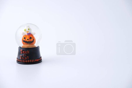 Foto de Un primer plano de una bola de nieve de calabaza de resina de Halloween aislada sobre fondo blanco - Imagen libre de derechos