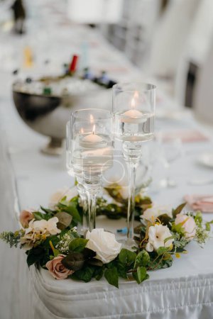 Téléchargez les photos : Un plan vertical de bougeoirs en verre et de fleurs sur une table de mariage - en image libre de droit