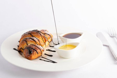 Photo for A closeup of a croissant with dripping chocolate served with sauces - Royalty Free Image