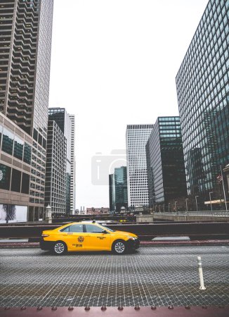 Foto de Un primer plano de un taxi amarillo cruza el río en la carretera en el centro de Chicago - Imagen libre de derechos
