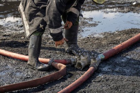 Téléchargez les photos : Un gros plan de pompier mâle mains tuyau roulant - en image libre de droit