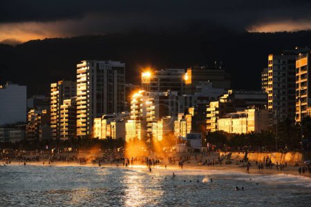 Foto de Una multitud de personas disfrutando de la majestuosa puesta de sol en la playa de Ipanema en Río de Janeiro, Brasil - Imagen libre de derechos