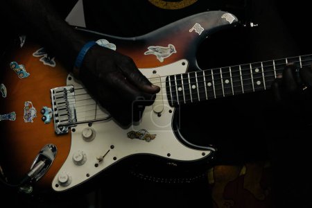 Foto de Una vista de cerca de una guitarra eléctrica en una mano de jugador - Imagen libre de derechos