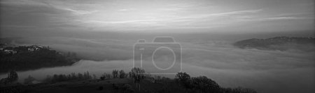 Téléchargez les photos : Vue panoramique en noir et blanc d'un paysage avec une mer de brouillard dans les collines de Rosora, Italie - en image libre de droit