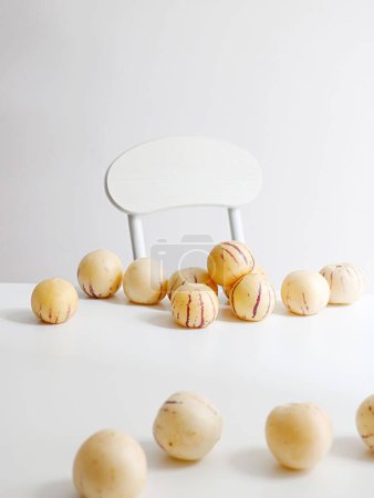 Téléchargez les photos : Un plan vertical de melons pepino frais sur une table blanche avec une chaise en arrière-plan - en image libre de droit