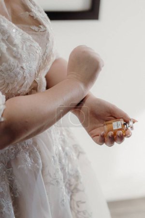 Foto de Un primer plano de las manos de la novia aplicando perfume - Imagen libre de derechos
