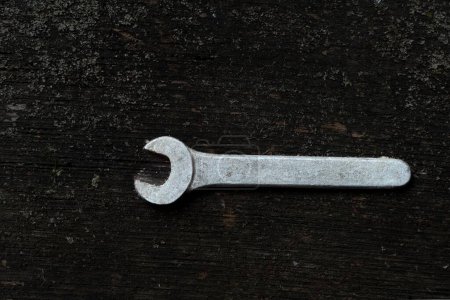 Photo for A top view of a metal wrench on a wooden surface - Royalty Free Image